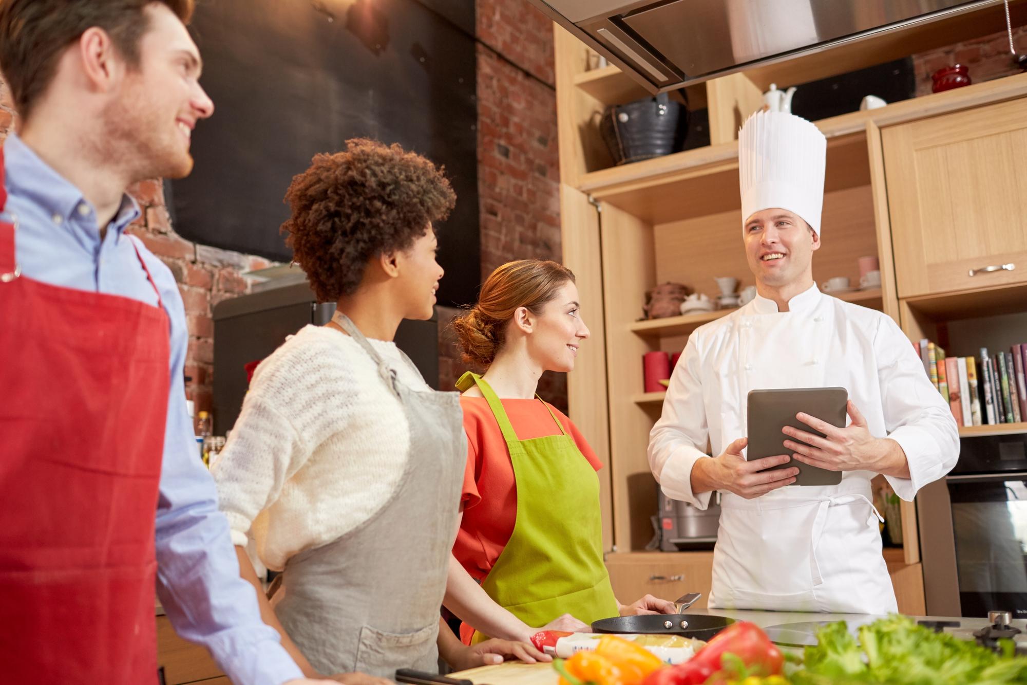 Workshop group listening to instructor in modern kitchen